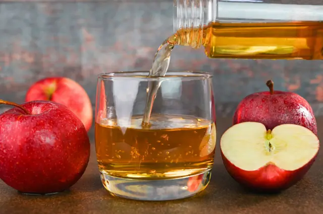 Du jus de pomme servi dans un verre 