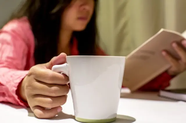 యువతి చేతిలో కాఫీ కప్పు