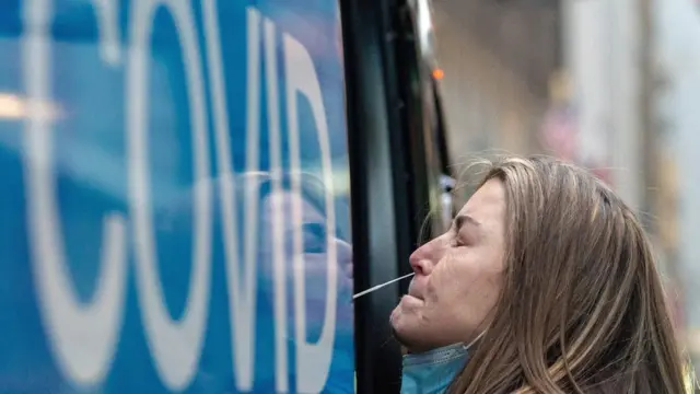 A woman takes a coronavirus disease (COVID-19) test at a pop-up testing site as the Omicron coronavirus variant continues to spread in Manhattan, New York City, U.S., December 27, 2021