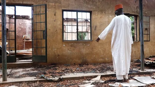 Ọkunrin kan duro ni iwaju lleewe kan ti wọn kọlu.