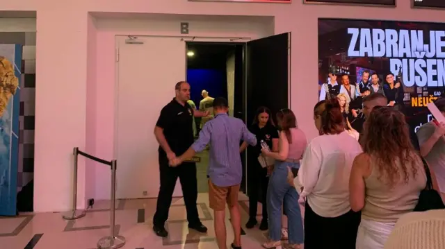 Muškarac kontroliše publiku koja ulazi u salu