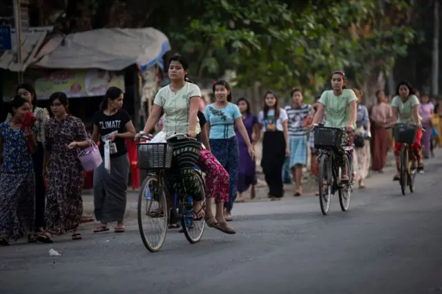 လမ်းပေါ်မှာ စက်ဘီးနင်းလာတဲ့ အမျိုးသမီးတွေ နဲ့ လမ်းလျှောက်သွားနေတဲ့ အမျိုးသမီးတွေ