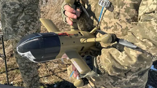 Український солдат тримає в руках безпілотник-перехоплювач «Стінг» перед випробувальним польотом 22 лютого 2026 року в Дніпропетровській області, Україна.
