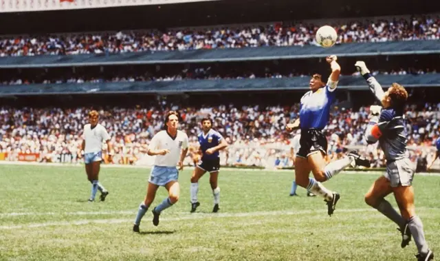 الأرجنتيني دييغو مارادونا يسجل هدفاً بيده في مرمى إنجلترا في مونديال 1986