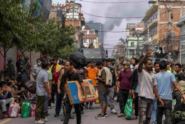 काठमाण्डूको चारखाल नजिकै जेलबाहिर भाग्न खोजेका कैदीबन्दीहरूलाई नियन्त्रणमा लिने प्रयासमा सैनिकहरू। अघिल्लो भागमा टीभी स्क्रिन बोकिरहेका एक व्यक्ति र उनको छेउमा कैदीहरूको भीड र पृष्ठभूमीमा एउटा हरियो रङ्गको सैनिक ट्रक र छेउपट्टी केही सैनिकहरू देखिन्छन्