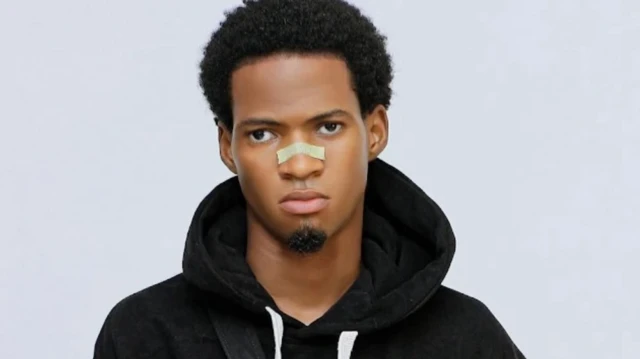 Sanku Comedy wọ aṣọ dúdú tó sì lẹ nǹkan mọ́ imú rẹ