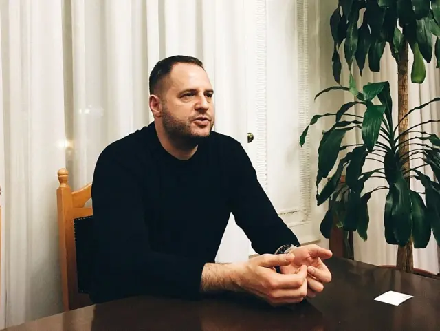 Ермак в черном джемпере сидит за столом.