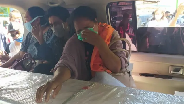 Keluarga menangis di depan peti jenazah seorang PMI asal NTT.