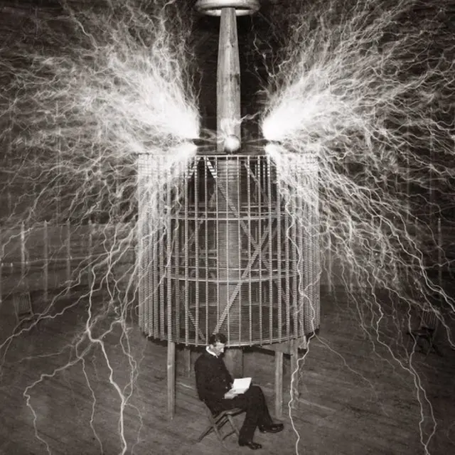 Tesla akiwa ameketi katika maabara yake ya Colorado Springs na "Magnifying transmitter" mnamo 1899.