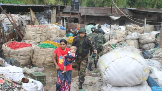 বাড়িটি থেকে উদ্ধার করে এক নারীকে নিরাপদ আশ্রয়ে সরিয়ে নিয়ে যাওয়া হচ্ছে।