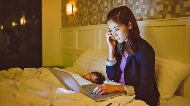 Жінка працює в ліжку