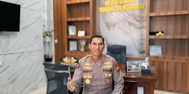 Kabid Humas Polda Bengkulu, AKBP Andy Pramudya Wardana berseragam lengkap polisi dengan latar belakang tulisan Bidhumas Polda Bengkulu.