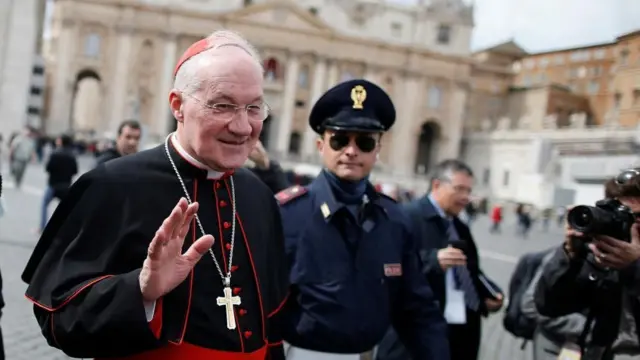 Cardinal Marc Ouellet of Canada walks through Saint Peter's Square as he leaves at the end of a meeting in
