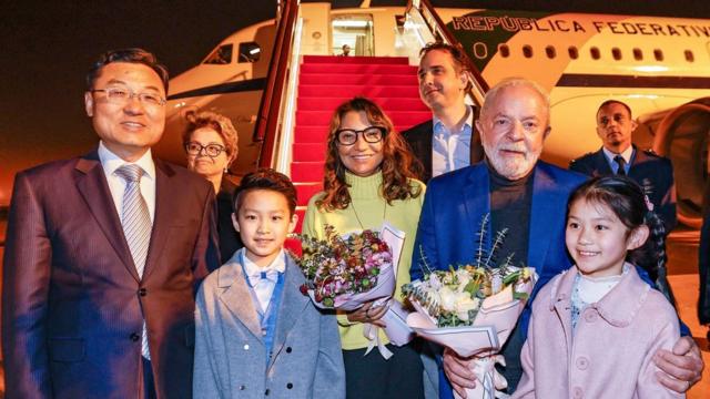 Brazil"s President Luiz Inacio Lula da Silva holds flowers next to First Lady Rosangela "Janja" da Silva and Vice Minister of Foreign Affairs of China Xie Feng, as he arrives in Shanghai, China, April 13, 2023