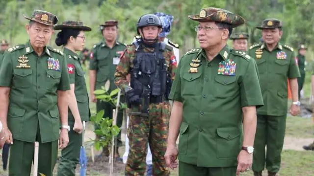 စစ်ယူနီဖောင်းအစိမ်းရောင်ဝတ်ပြီး ဦးထုပ်ဆောင်းထားတဲ့ဗိုလ်ချုပ်မှူးကြီးမင်းအောင်လှိုင်နဲ့ဒုတိယဗိုလ်ချုပ်မှူးကြီးစိုးဝင်းကို တခြားတပ်အရာရှိတွေနဲ့အတူ တွေ့ရပါတယ်။ သစ်ပင်စိုက်ပျိုးပွဲမှာ တွေ့ရတာပါ။