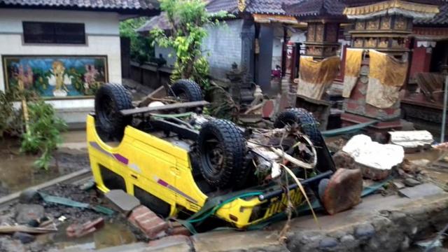 a ruined car that was rolled over after a tsunami hit Sunda Strait, in Anyer, Banten, Indonesia, 23 December 2018