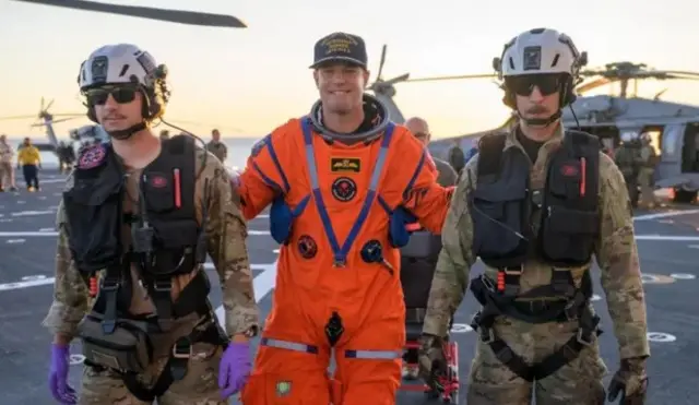 Джереми Хансен покидает полетную палубу после своего возвращения