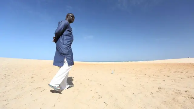 Gambian national Ebrima Sanneh, who has been in exile since 2013, walks on a beach in Dakar, Senegal, December 5, 2016.
