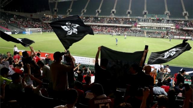 Demonstrators wave black Hong Kong flags in support of anti-government protesters at a football World Cup qualifier match between Hong Kong and Iran, at Hong Kong Stadium, China September 10, 2019.