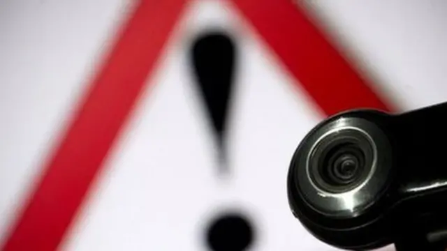 webcam y símbolo de advertencia