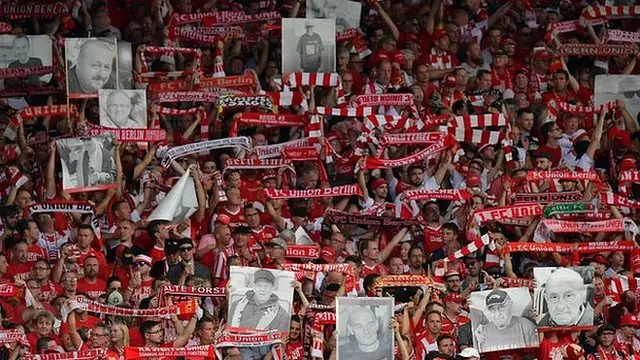 Fans holding up posters of the deceased
