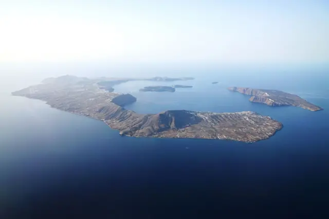 Santorini'nin uzaktan çekilmiş görüntüsü. Ortada suyun altında kalan kaldera görülüyor.