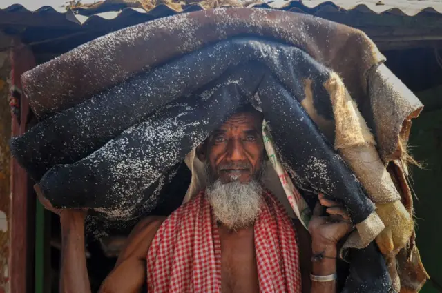 عامل من بنغلاديش يُحمل الجلود الخام على رأسه خلال عملية نقلها، في ظلّ تزايد التحديات التي تواجهها هذه الصناعة.