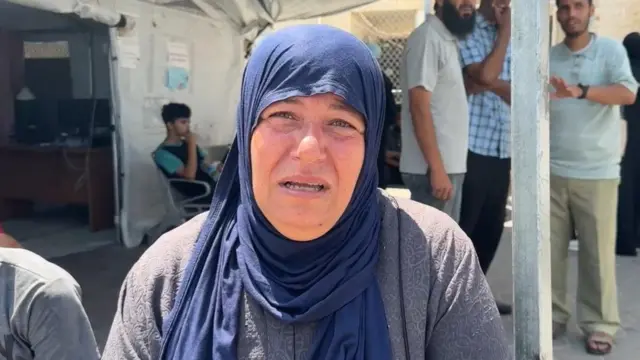 ガザ中心部ヌセイラトのアル・アウダ病院でBBCのインタビューに答えるパレスチナ人女性。青いスカーフを頭に巻いている（2025年6月24日）