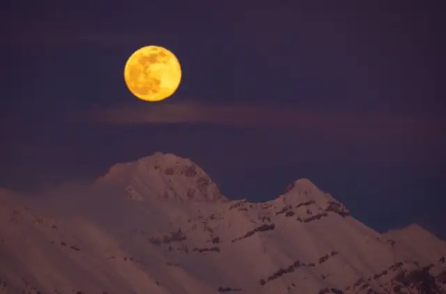 يظهر "قمر الثلج" في فبراير/ شباط خلف جبال الألب في إيطاليا (2023)