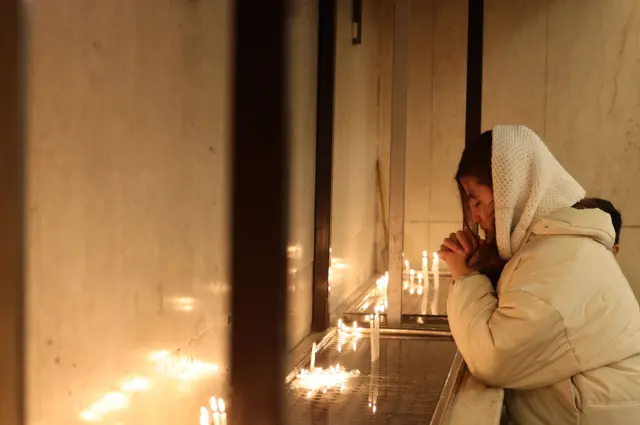 امرأة إيرانية مسيحية تشعل شمعة وتصلي خلال قداس صلاة رأس السنة الجديدة في كنيسة القديس سركيس في طهران