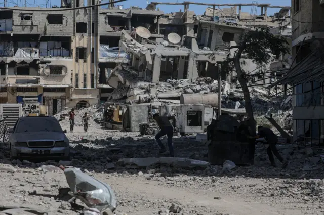 Palestinos andam em área destruída após ataques aéreos de Israel na Cidade de Gaza, no dia 30 de setembro de 2025.