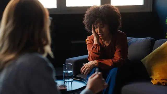 የተጨነቀች የምትመስል ሴት እያማከራቻት ካለች ሴት ፊት ለፊት ተቀምጣ