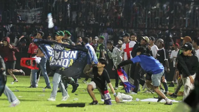 Suporter Arema FC memasuki lapangan setelah tim yang didukungnya kalah dari Persebaya dalam pertandingan sepak bola BRI Liga 1 di Stadion Kanjuruhan, Malang, Sabtu (1/10/2022).
