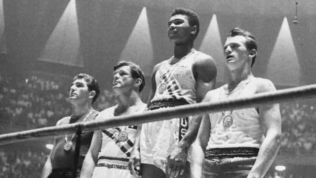 عکس کلی در حالیکه بالاتر از بقیه روی سکو ایستاده به یکی از تصاویر نمادین المپیک تبدیل شده است