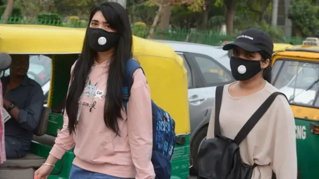 दिल्ली में मास्क पहन कर घूमते लोग