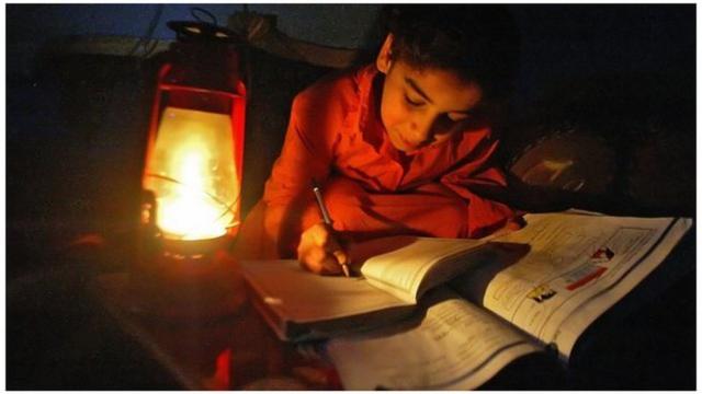 طفل يدرس على ضوء شمعة