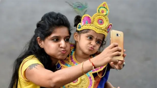 తల్లితో సెల్ఫీ తీసుకుంటున్న చిన్నారి