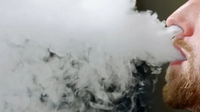 Мужчина выдыхает пар