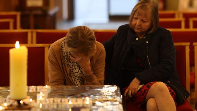 Constituent Ruth Verrinder and former councillor and mayor Judith McMahon (L) pay their respects at St Michael All Angels Church, following the stabbing of UK Conservative MP Sir David Amess.