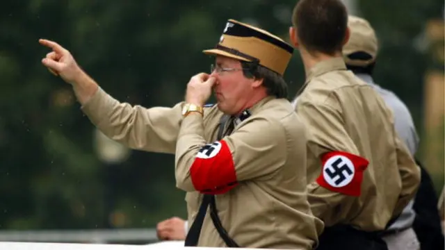 Homens vestindo uniforme com símbolos nazistas