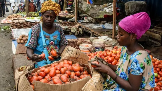 Des vendeuses nettoient des tomates dans Mabibo Street sans porter de masque malgré les cas confirmés de coronavirus COVID-19 à Dar es Salaam, en Tanzanie, le 16 avril 2020.