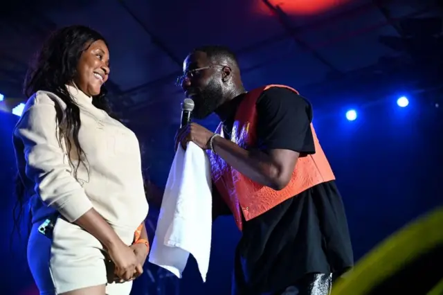 Mwimbaji wa Ufaransa na Ivory Coas Vegedream (Kulia) akitumbuiza na mmoja wa mashabiki wake kwenye jukwaa kwenye Tamasha la Muziki wa Mjini Anoumabo (Femua) mjini Abidjan mnamo Septemba 11, 2021.