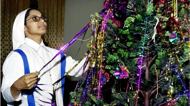 বড়দিনের ক্রিসমাস ট্রি সাজাচ্ছেন একজন ধর্মযাজিকা