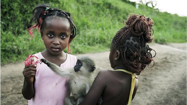 Deux filles qui jouent avec un petit singe