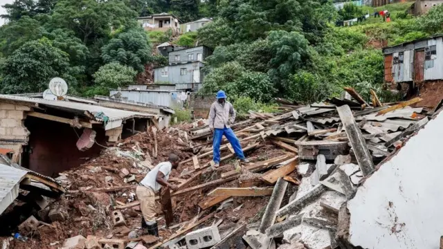 Man dey stand on one debris for Clermont, near Durban