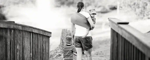 背着孩子的妈妈，还可以手牵另一个孩子