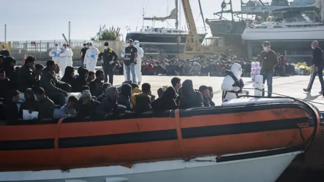 مهاجرون يصلون على متن زورق دورية في ميناء روتشيلا يونيكا، إيطاليا