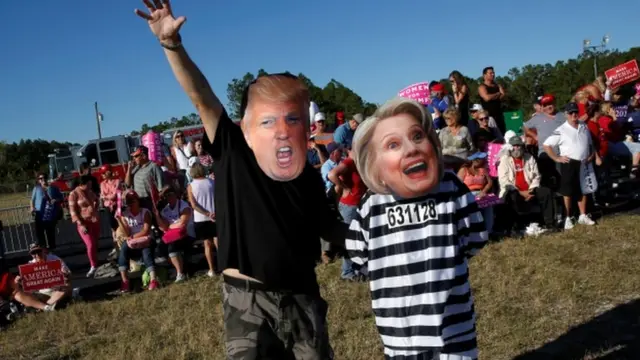 ट्रंप और हिलेरी का मास्क पहने लोग