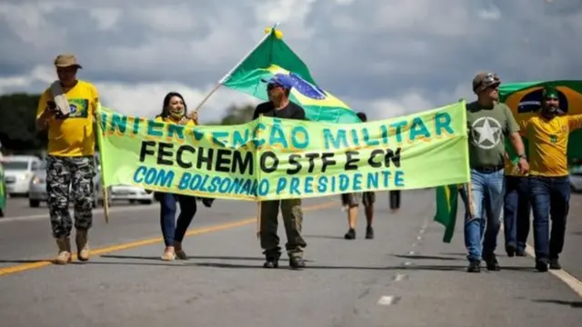 Manifestantes seguram cartazes pedindo fechamento do STF e do Congresso durante ato pró-Bolsonaro