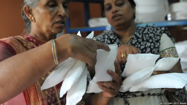 Savitaben Patel, CEO of Self Employed Women's Association (SEWA) and Assistant Project Manager, Nilam Solank check the quality of low cost sanitary pads made by members at their facility in Ahmedabad on September 3, 2012.